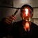 A glassblower working with a rod containing a molten glass bubble